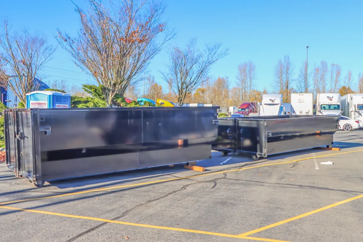 Professional dumpster rental service with roll-off container on residential driveway in Portage Lakes